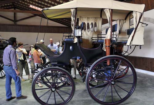 Miguel and several members of the group look at an unusual, recently restored American carriage
