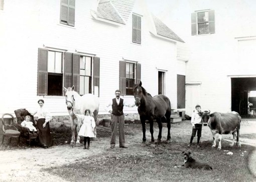 family and animals in front of house in NH